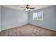 A carpeted bedroom featuring a ceiling fan, window and light blue walls at 9370 Burning Sage Ave, Las Vegas, NV 89149
