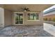 Spacious covered patio with brick pavers, modern ceiling fan, and access to the home through sliding glass doors at 9370 Burning Sage Ave, Las Vegas, NV 89149