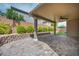 Inviting covered patio features stylish brick pavers, a ceiling fan, and a privacy wall with lush landscaping at 9370 Burning Sage Ave, Las Vegas, NV 89149