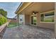 Covered patio with brick pavers, ceiling fan, and seamless access to the indoors through sliding glass doors and large windows at 9370 Burning Sage Ave, Las Vegas, NV 89149