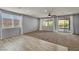 Bright living room featuring a ceiling fan, light gray walls, and sliding glass doors to the back patio at 9370 Burning Sage Ave, Las Vegas, NV 89149