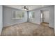 Spacious living area with neutral carpet, large windows, and a ceiling fan at 9370 Burning Sage Ave, Las Vegas, NV 89149