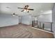 Spacious loft area featuring neutral carpet, two ceiling fans, and natural lighting at 9370 Burning Sage Ave, Las Vegas, NV 89149