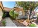 Close up view of the front door and landscaping, complete with mature trees and decorative rock at 1185 Ponce De Leon Ave, Las Vegas, NV 89123