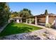 Lush backyard showcasing a guest house, covered patio, well-manicured lawn, and meticulous landscaping at 1450 Rancho Cir, Las Vegas, NV 89107