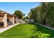Serene backyard offering a private retreat with a well-maintained lawn, covered patio, and mature trees at 1450 Rancho Cir, Las Vegas, NV 89107
