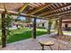 Expansive backyard featuring a covered patio, lush lawn, mature trees, and a glimpse of the sparkling pool at 1450 Rancho Cir, Las Vegas, NV 89107