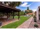 Picturesque backyard featuring a covered patio, pool view, lush landscaping, and serene outdoor entertaining spaces at 1450 Rancho Cir, Las Vegas, NV 89107