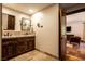 This bathroom has dual sinks with handsome wood cabinets and travertine floors at 1450 Rancho Cir, Las Vegas, NV 89107