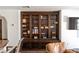 A custom wood built-in with dark wood cabinets and shelving filled with books and decor at 1450 Rancho Cir, Las Vegas, NV 89107