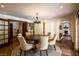 Brightly lit dining area features a chandelier above a round table with comfortable cushioned seating and views into other rooms at 1450 Rancho Cir, Las Vegas, NV 89107