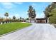 A long circular driveway, with porte cochere, leads to this home surrounded by expansive lawns and mature landscaping at 1450 Rancho Cir, Las Vegas, NV 89107