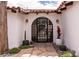 A front entrance featuring a wrought iron door, desert landscaping, and sconce lighting at 1450 Rancho Cir, Las Vegas, NV 89107