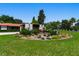Lush circular front lawn featuring a central water feature and mature landscaping provides a grand entrance to the home at 1450 Rancho Cir, Las Vegas, NV 89107
