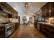 Expansive kitchen with dark cabinets, stainless steel appliances, tile flooring, and decorative hanging lights above a dining area at 1450 Rancho Cir, Las Vegas, NV 89107