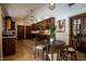 A wooden kitchen area with a small table, decorative hanging lights, tile floors, wooden cabinets, and stainless steel appliances at 1450 Rancho Cir, Las Vegas, NV 89107