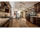 Spacious kitchen with stainless steel appliances, dark cabinets, and a marble countertop with a dining area and decorative lighting at 1450 Rancho Cir, Las Vegas, NV 89107