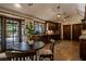 A wooden kitchen area with a small table, decorative hanging lights, tile floors, wooden cabinets, and glass paneled doors at 1450 Rancho Cir, Las Vegas, NV 89107