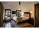 A naturally lit main bedroom with tiled floors, a comfortable chair, and a queen-sized bed at 1450 Rancho Cir, Las Vegas, NV 89107