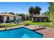 Inviting pool area with a diving board, lush landscaping, a fire pit, and additional backyard buildings at 1450 Rancho Cir, Las Vegas, NV 89107