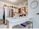 Well-lit kitchen with stainless steel appliances, light countertops, and stylish stools at the breakfast bar at 5751 Hacienda Ave # 135, Las Vegas, NV 89122