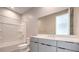 Modern bathroom featuring sleek vanity, large mirror, and a shower over tub combination at 5913 Flowering Hill Ct, Las Vegas, NV 89131