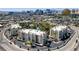 Stunning aerial view of residential buildings with mature trees, landscaping, pool and a distant city skyline at 725 N Royal Crest Cir # 214, Las Vegas, NV 89169