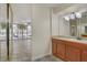 Bathroom with wood vanity, mirrors, and access to a screened patio with outdoor views at 725 N Royal Crest Cir # 214, Las Vegas, NV 89169
