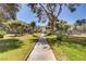 Scenic view of a paved walkway leading to the building, surrounded by mature trees and greenery at 725 N Royal Crest Cir # 214, Las Vegas, NV 89169