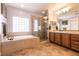 Primary bathroom with dual sink vanity, garden tub and glass enclosed shower at 7416 Redhead Dr, North Las Vegas, NV 89084