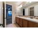 Bathroom with dual sinks, tile backsplash, and views to the main bedroom and shower area at 7416 Redhead Dr, North Las Vegas, NV 89084