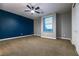 Bedroom featuring plush carpet, a textured accent wall, and a ceiling fan at 7416 Redhead Dr, North Las Vegas, NV 89084