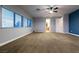 Spacious bedroom with a ceiling fan, wide windows and plush carpet at 7416 Redhead Dr, North Las Vegas, NV 89084