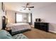 This bedroom has a ceiling fan, large bed, and dresser with television at 7416 Redhead Dr, North Las Vegas, NV 89084