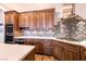 Well-appointed kitchen boasts stainless steel appliances, quartz countertops, and mosaic tile backsplash at 7416 Redhead Dr, North Las Vegas, NV 89084