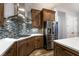 Gourmet kitchen with stainless steel appliances and wood cabinets with designer backsplash at 7416 Redhead Dr, North Las Vegas, NV 89084