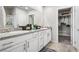 Bathroom with double sinks, granite counters, modern lighting, and a walk-in closet at 9068 Lennon Ln, Las Vegas, NV 89113