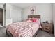 Bedroom with a plush bed, soft pink comforter, and matching bedside table with drawers at 9068 Lennon Ln, Las Vegas, NV 89113