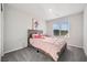 Sunlit bedroom featuring a plush bed and a window offering views of the outside at 9068 Lennon Ln, Las Vegas, NV 89113