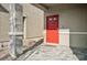 Inviting front door with red finish, complemented by a stone pillar and tiled entryway at 9068 Lennon Ln, Las Vegas, NV 89113