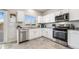 Bright kitchen features white cabinetry, stainless steel appliances, and granite countertops at 9068 Lennon Ln, Las Vegas, NV 89113
