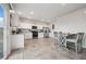 Bright kitchen with stainless steel appliances, white cabinetry, tile floors, and a large dining table at 9068 Lennon Ln, Las Vegas, NV 89113
