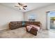 Cozy living area boasting tile floors, a large sectional sofa, and a sliding glass door at 9068 Lennon Ln, Las Vegas, NV 89113