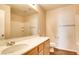 Bright bathroom featuring warm wooden cabinets, a sleek sink, and bright lighting at 9115 Canoga Canyon Ct # 102, Las Vegas, NV 89149