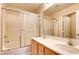 Double sink bathroom with shower and wood cabinets at 9115 Canoga Canyon Ct # 102, Las Vegas, NV 89149