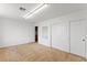 Clean bedroom with light carpet, white walls, sliding closet doors, and bright overhead lighting at 10021 Skipper Ct, Las Vegas, NV 89117
