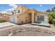 Attractive two-story home with a three-car garage, a welcoming porch, and desert-style rock landscaping at 10021 Skipper Ct, Las Vegas, NV 89117