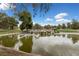 Scenic view of a tranquil pond with a waterfall, lush trees, and a blue sky at 10021 Skipper Ct, Las Vegas, NV 89117