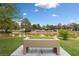Picturesque park pond view with a bench, waterfall feature, and green trees at 10021 Skipper Ct, Las Vegas, NV 89117