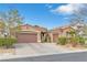 Charming single-story home featuring a three-car garage, terra cotta roof, and desert landscaping at 10024 Scenic Walk Ave, Las Vegas, NV 89149